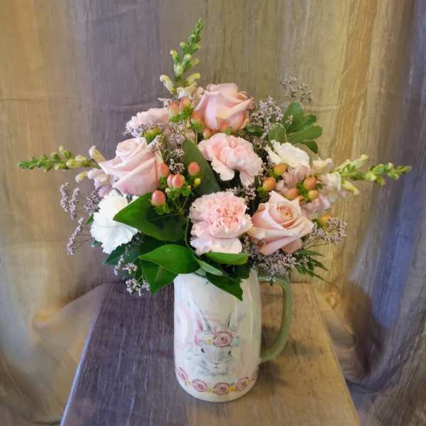 Pink roses and carnations in a rabbit-print pitcher vase