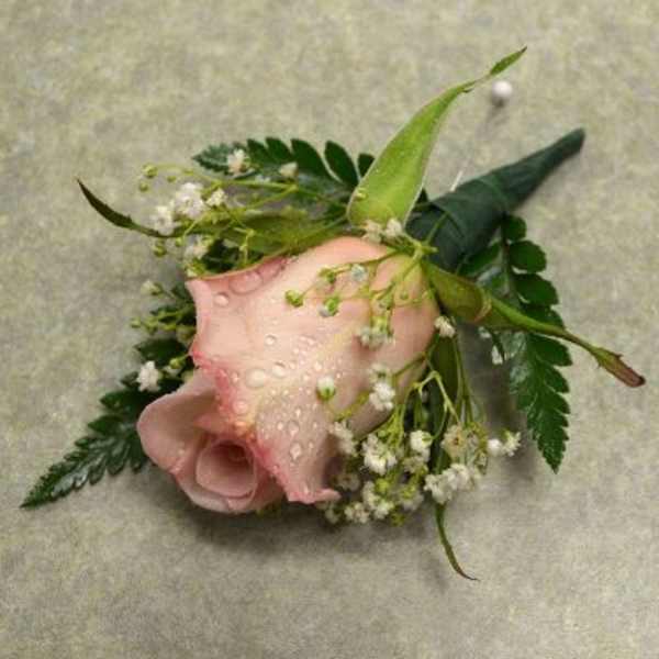 Pink calla lily corsage with small white flowers and greenery