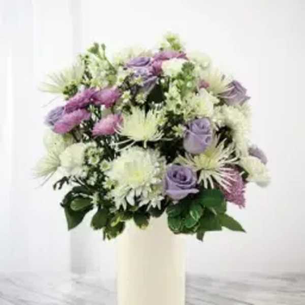 Lavender and white bouquet in a cream vase