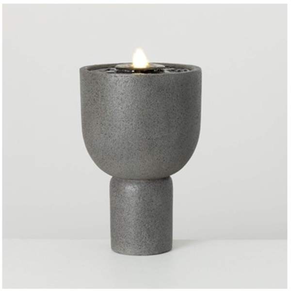 Gray pedestal candle holder with a lit candle
