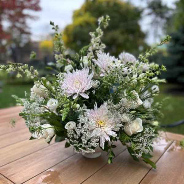 White and pale pink floral arrangement in a low vase
