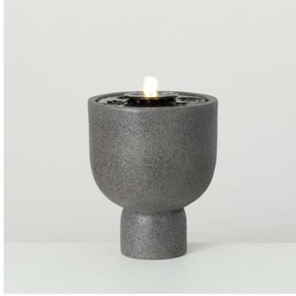 Gray textured candle holder with a lit candle