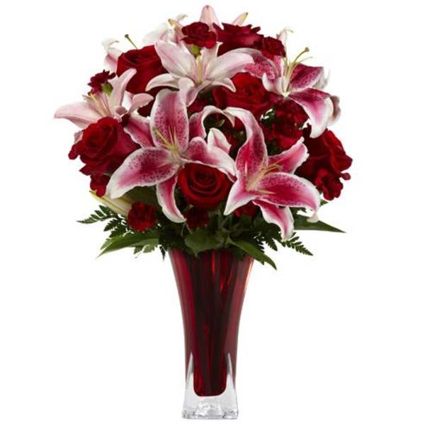 Red roses and pink lilies arranged in a tall red vase