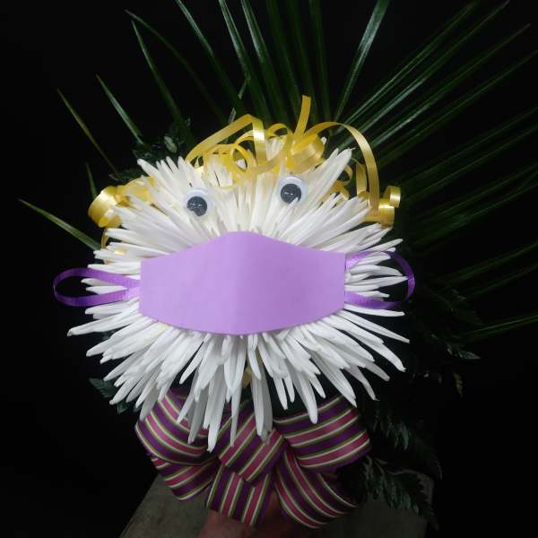 White chrysanthemum face with ribbon and palm fronds