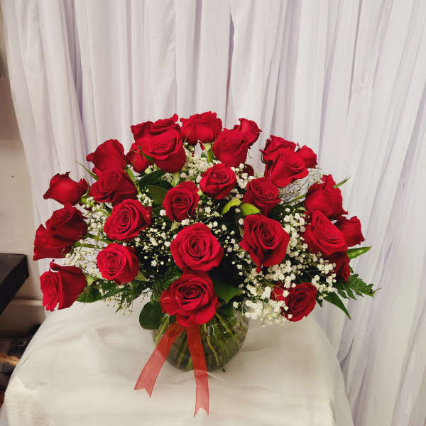 Bouquet of red roses in a glass vase with white filler flowers