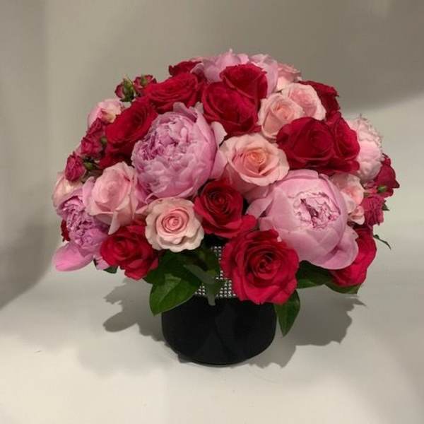 Bouquet of red and pink roses in a black vase
