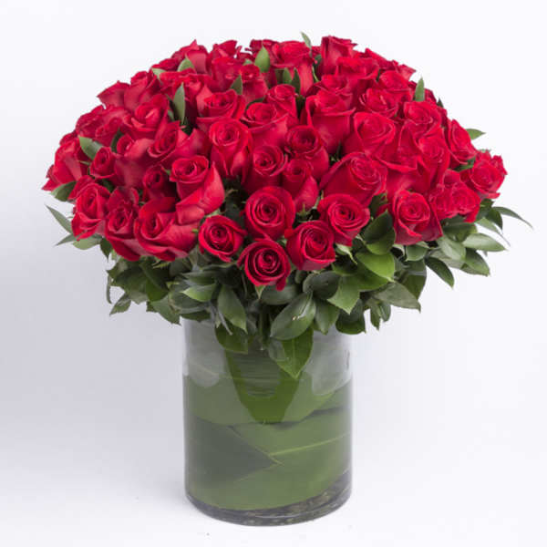 Red roses arranged in a clear glass vase