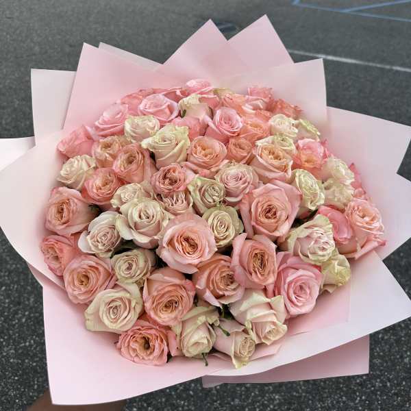 Large bouquet of pale pink and cream roses wrapped in pink paper