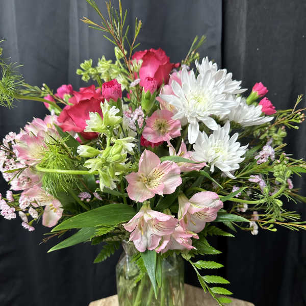 Mixed pink and white flowers arranged in a glass vase
