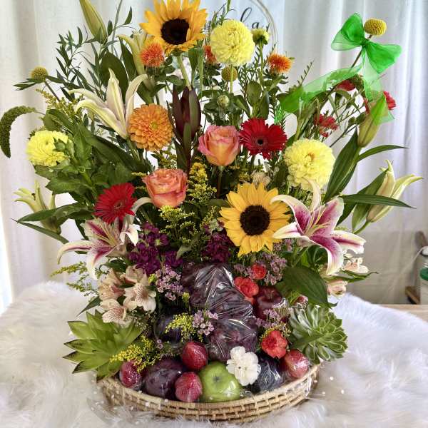 Mixed flower basket with sunflowers, lilies, roses, and fruit