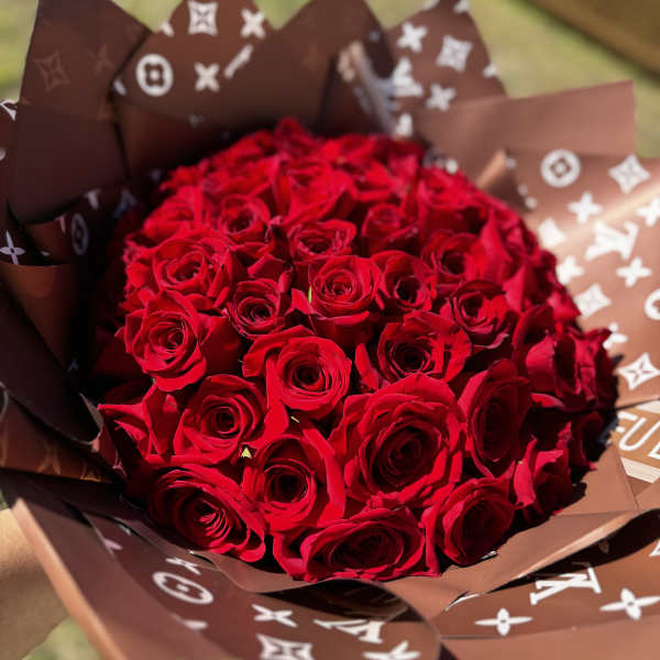 Bouquet of red roses wrapped in brown patterned paper