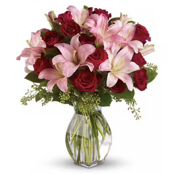 Pink lilies and red roses in a clear glass vase