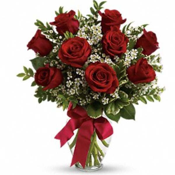 Bouquet of red roses with white filler flowers in a glass vase