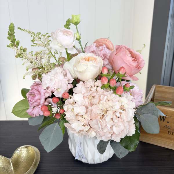 Pink and white floral arrangement in a white vase