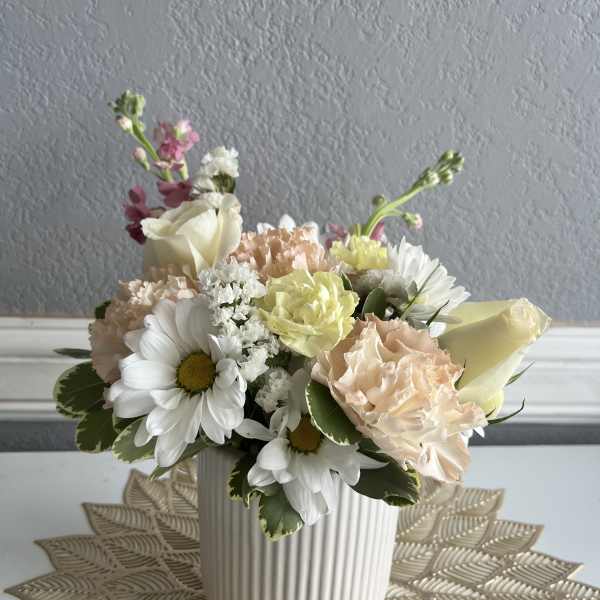 Pastel flower arrangement in a ribbed white vase