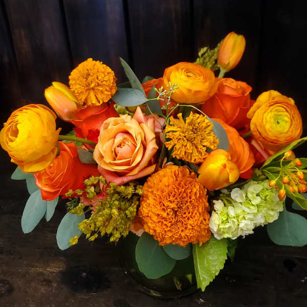 Orange and yellow flower arrangement in a black vase
