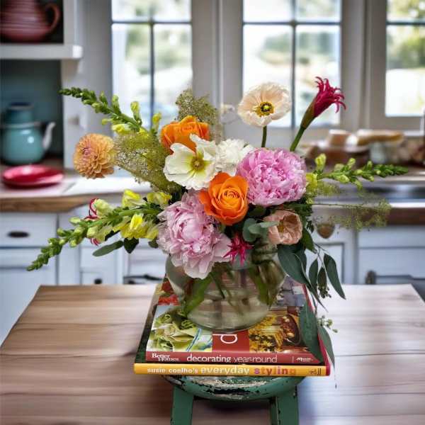 Mixed bouquet in a glass vase with orange, pink, and white blooms