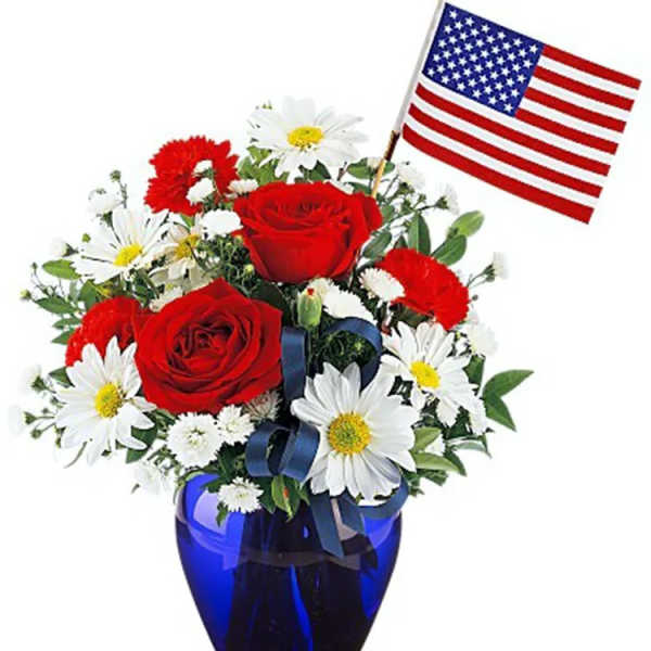 Red roses and white daisies in a blue vase with a small American flag