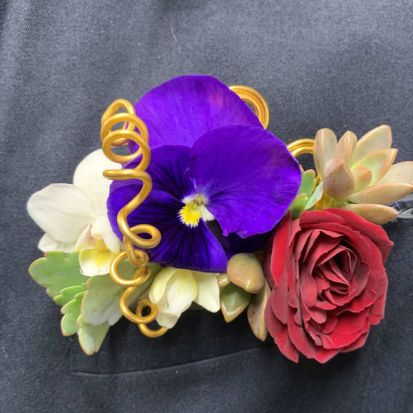 Floral wrist corsage with purple pansy, red rose, and succulents