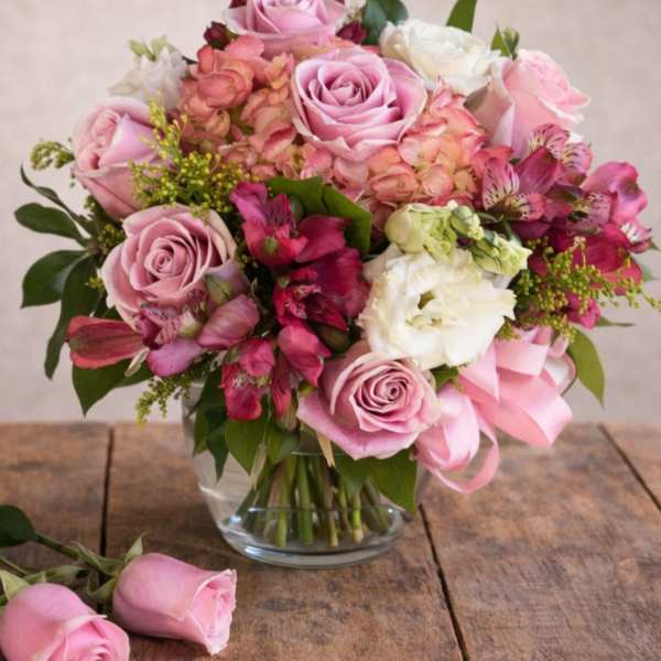 Pink and white rose bouquet in a clear glass vase