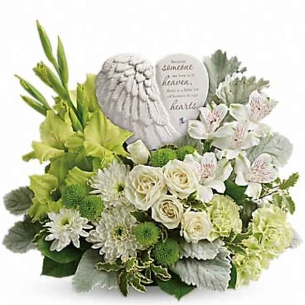 White sympathy bouquet with roses and daisies around a memorial stone