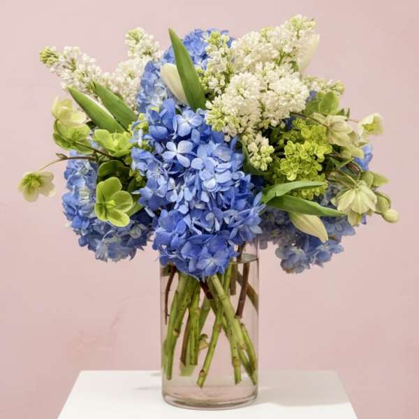 Blue and white hydrangea bouquet in a clear glass vase