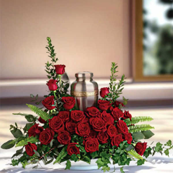 Red rose centerpiece around a silver urn on a table