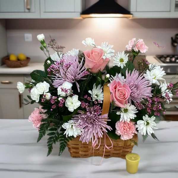 Basket arrangement of pink roses, white daisies, and lavender mums