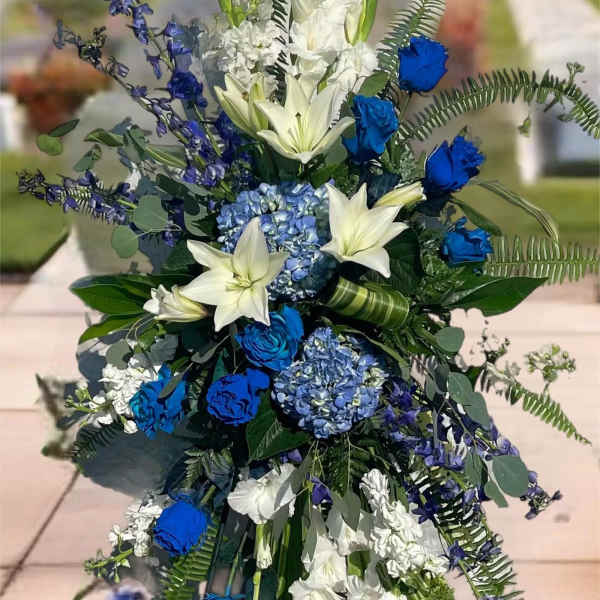 Tall blue and white floral standing spray on an easel