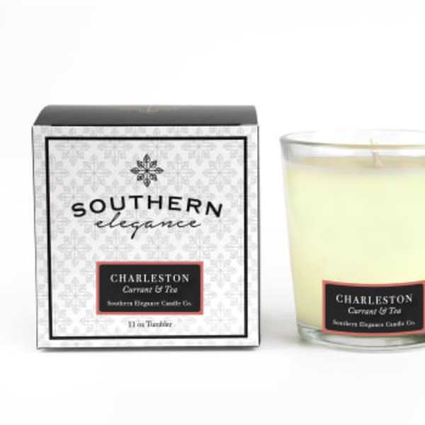 Boxed candle beside a glass jar candle labeled Charleston Currant & Tea
