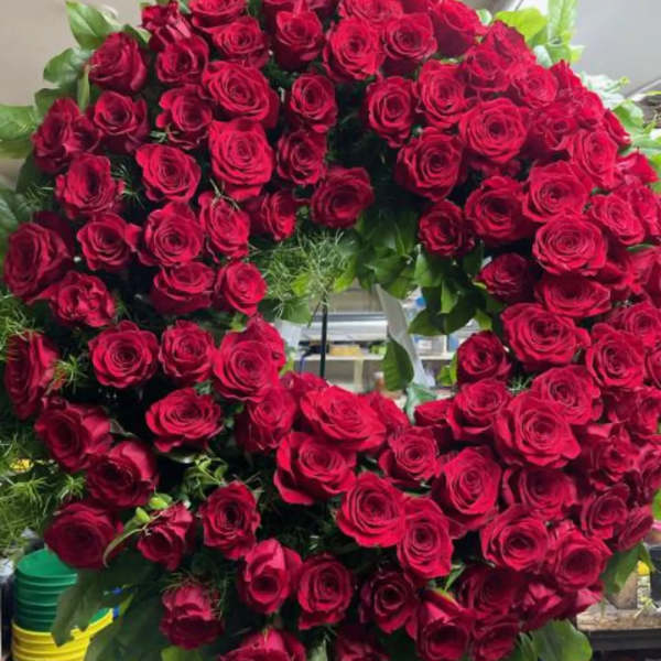 Large circular wreath of red roses with green foliage