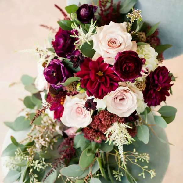 Bouquet of pale pink and deep burgundy flowers with eucalyptus