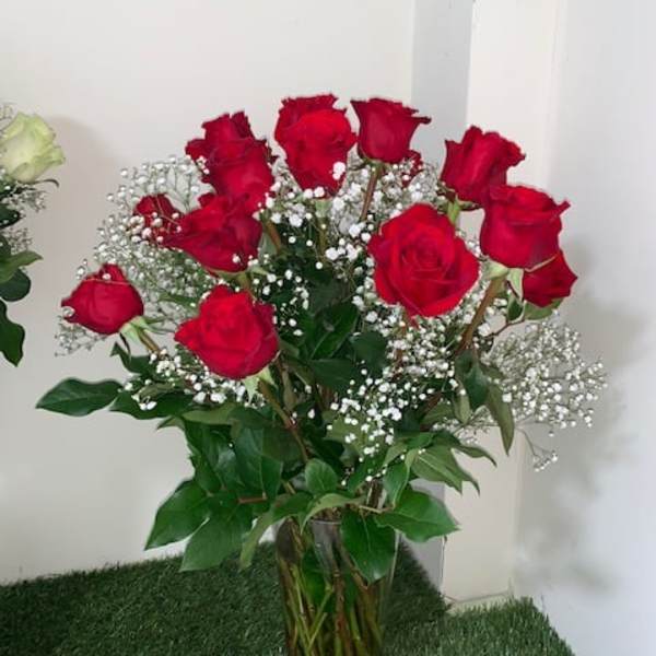 Bouquet of red roses with white baby's breath in a clear vase
