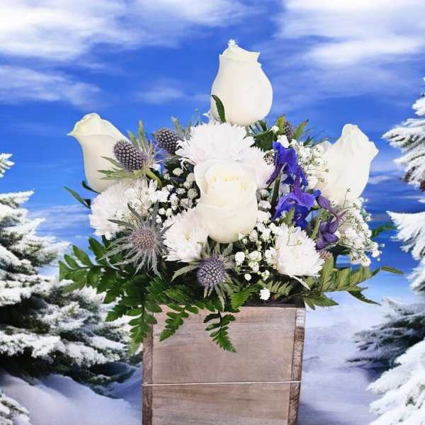 White roses and purple flowers in a wooden box