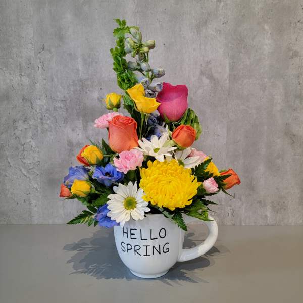 Colorful spring bouquet in a white mug with "HELLO SPRING" text