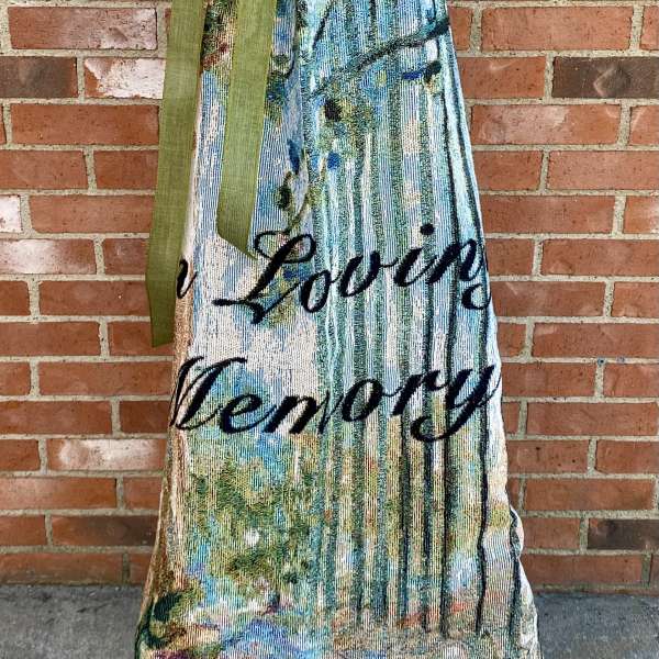 Decorative memorial blanket with a green bow and printed floral design