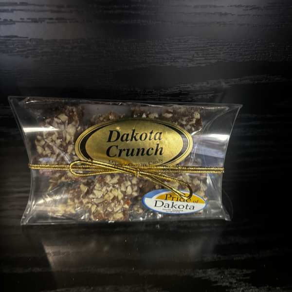 Clear bag of Dakota Crunch candy tied with a gold ribbon