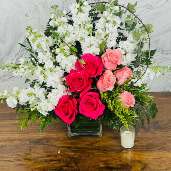 Pink and white rose arrangement in a square glass vase