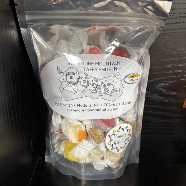 Clear bag of assorted wrapped taffy candies with holiday label