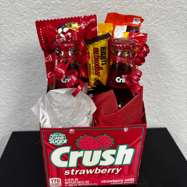 Gift box with soda bottles and candy bars wrapped in red ribbons