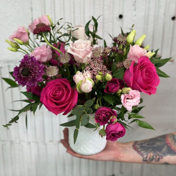 Pink and purple rose bouquet in a white vase
