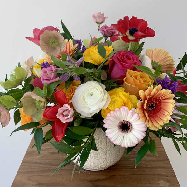 Mixed bouquet of colorful flowers in a patterned ceramic vase