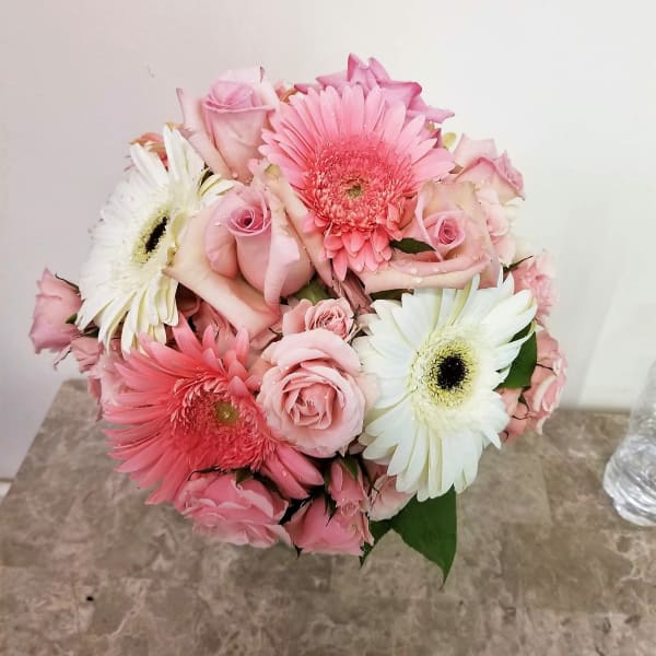 Pink roses and gerbera daisies in a compact bouquet
