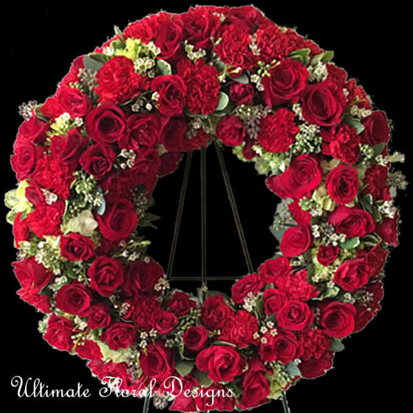 Large heart-shaped wreath of red roses on a black stand