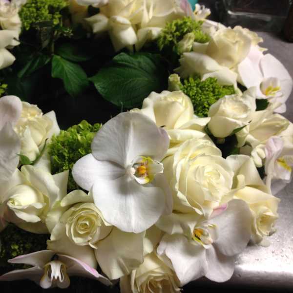 White rose and orchid wreath with green accents