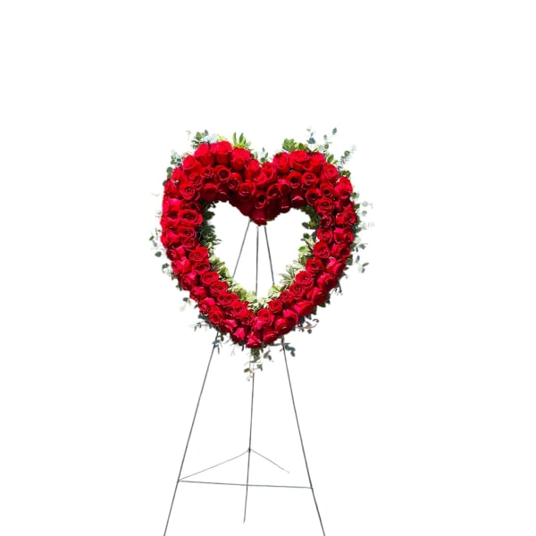 Heart-shaped standing wreath of red roses on an easel