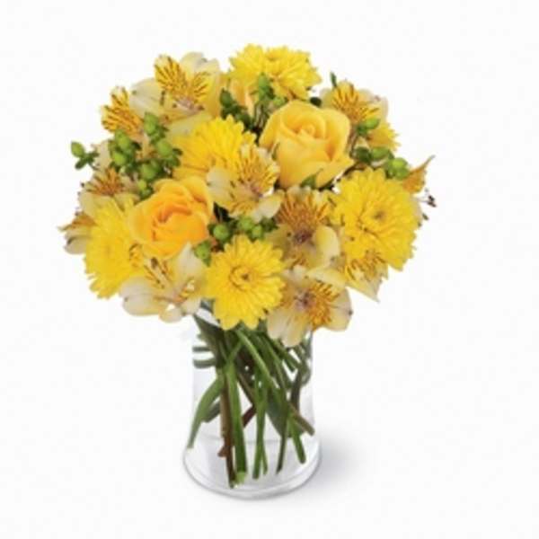 Yellow roses and daisies in a clear glass vase