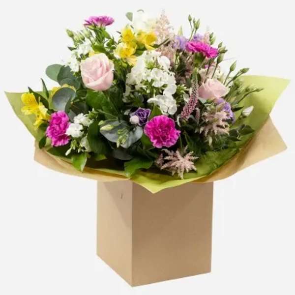 Mixed bouquet of pink, white, yellow, and purple flowers in brown wrap