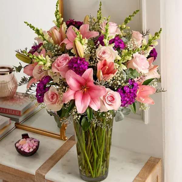 Pink lilies and roses in a clear glass vase