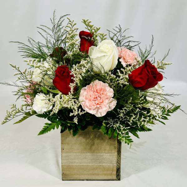 Red and white roses with pink carnations in a wooden box